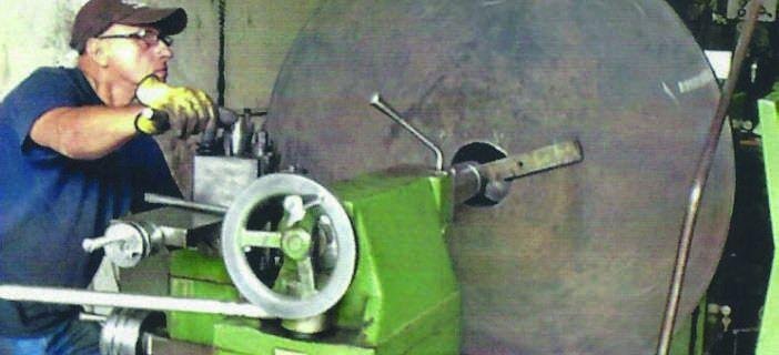 Operario maquinando un disco en el torno
